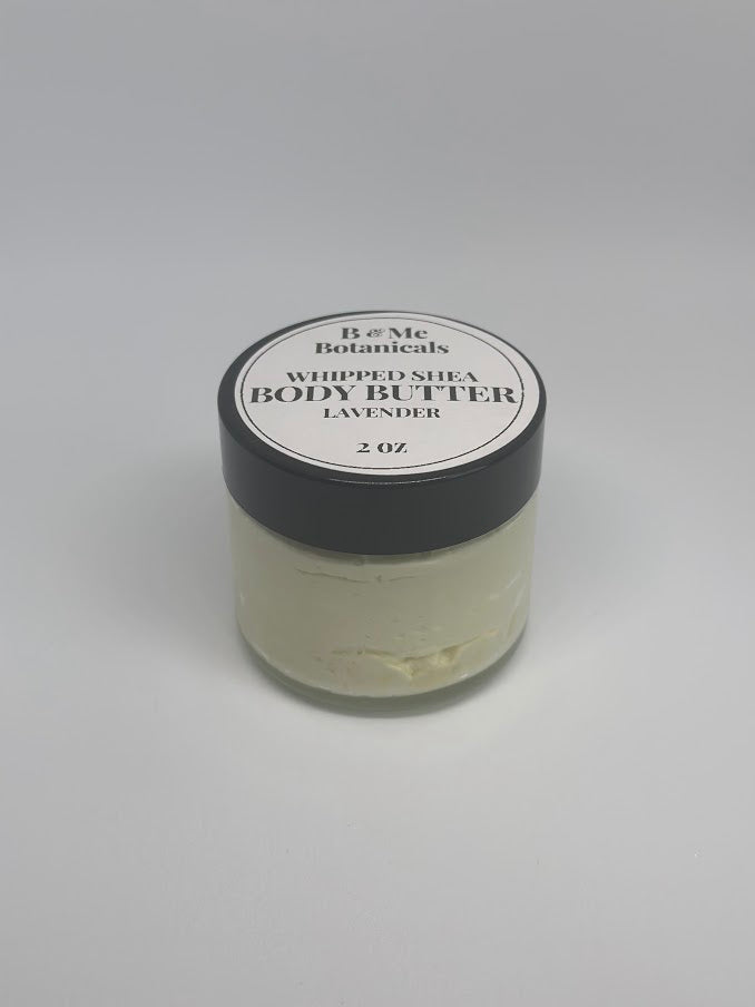 A two-ounce glass jar of whipped lavender shea butter with the lid on