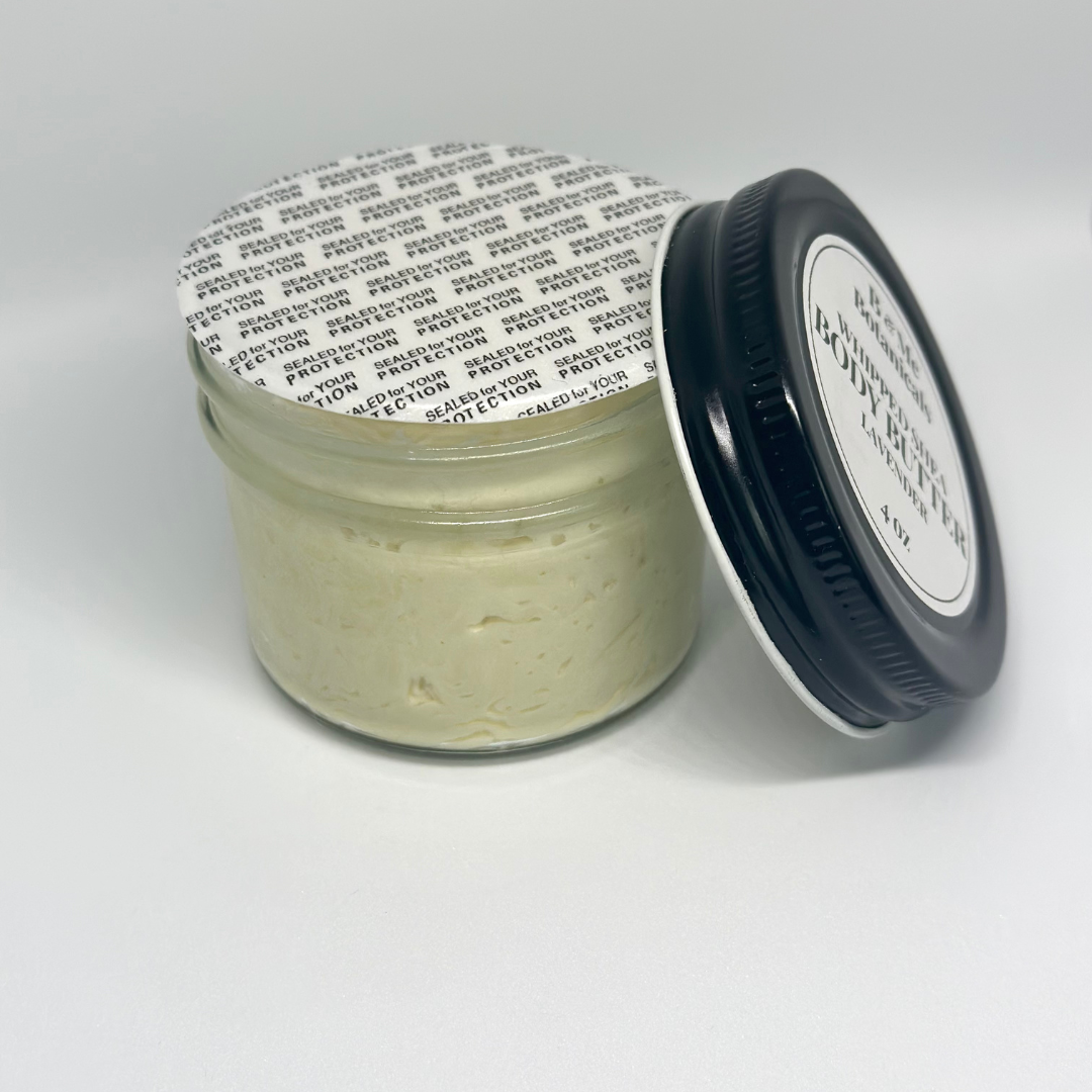 An open four ounce glass jar of whipped lavender shea butter with a safety seal